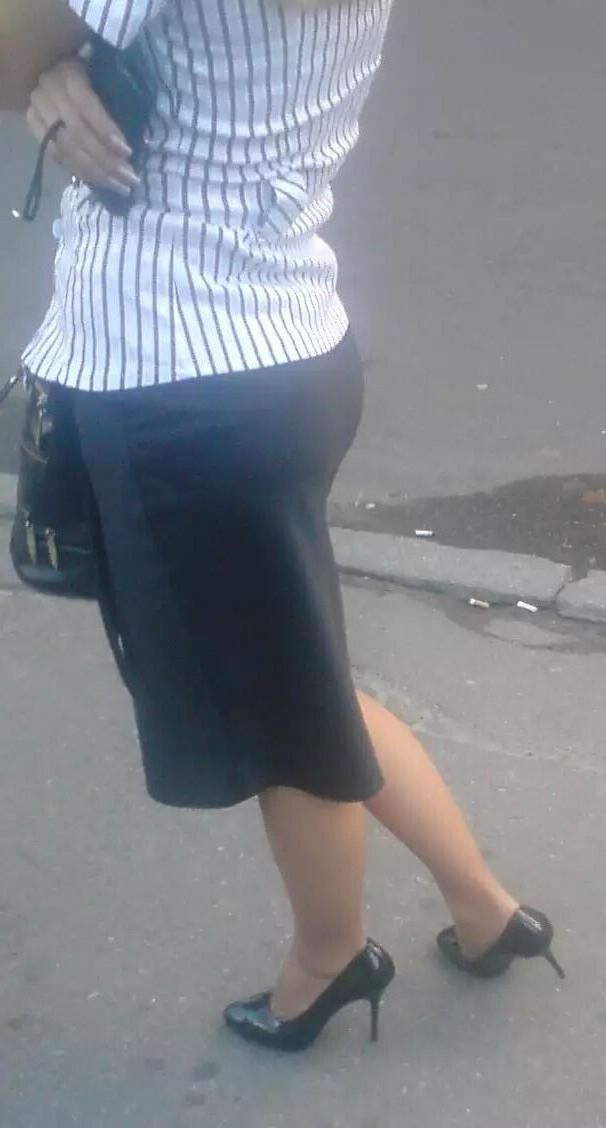 Girl in pencil skirt and heels on a bus stop