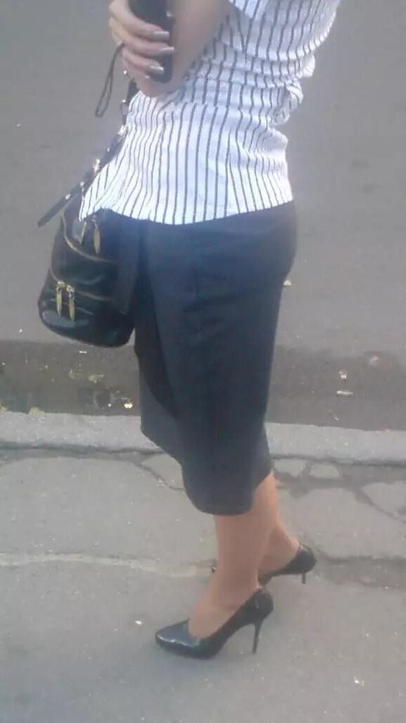 Girl in pencil skirt and heels on a bus stop