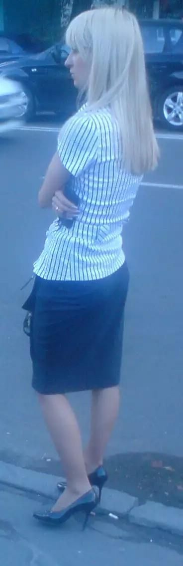 Girl in pencil skirt and heels on a bus stop