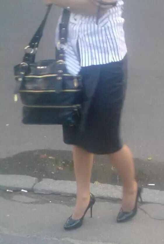 Girl in pencil skirt and heels on a bus stop