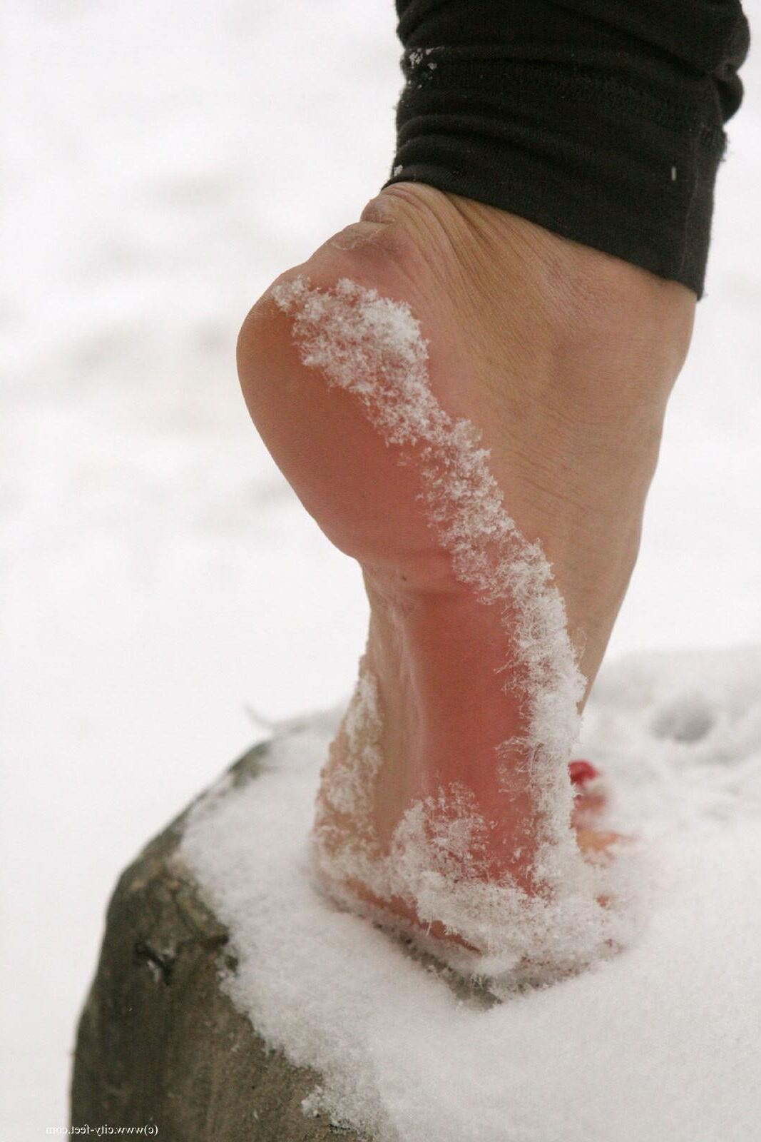 Garota corajosa! Pés descalços sexy na neve russa.