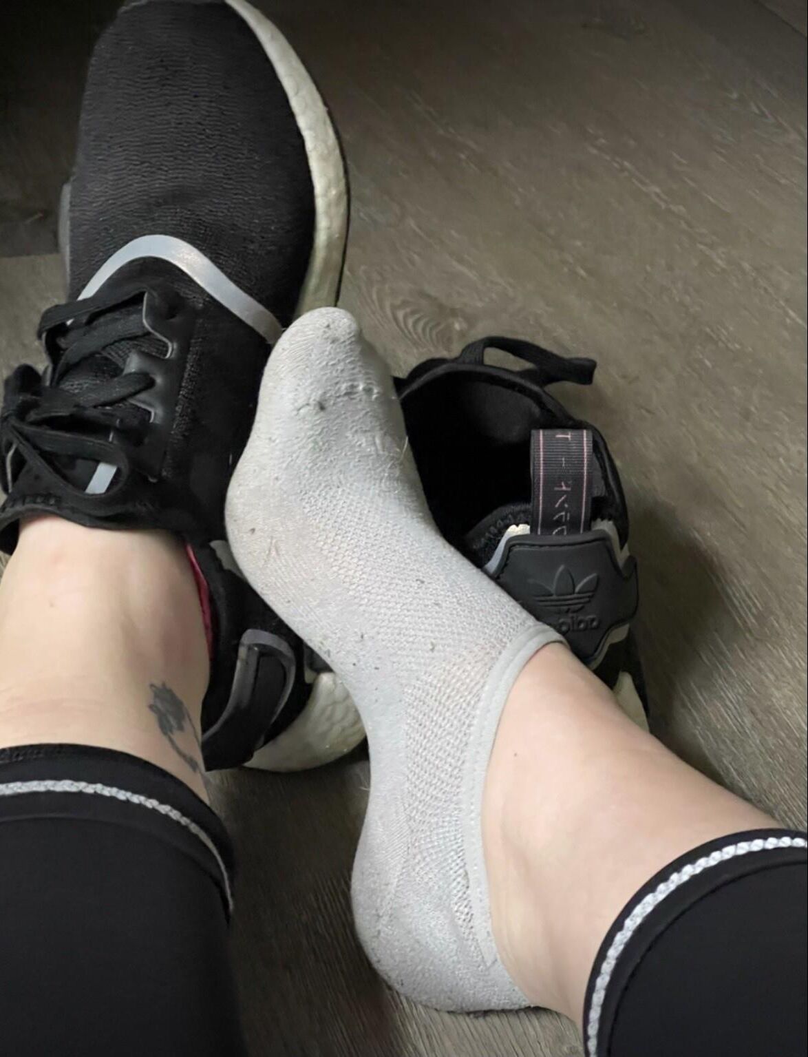 Ash zieht nach dem Fitnessstudio seine schwarzen Tennisschuhe aus