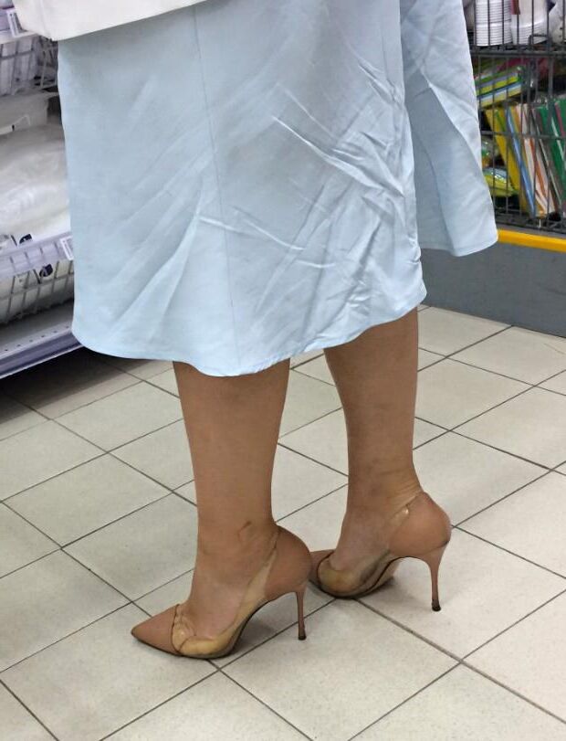 Mulher de salto transparente/nu no supermercado