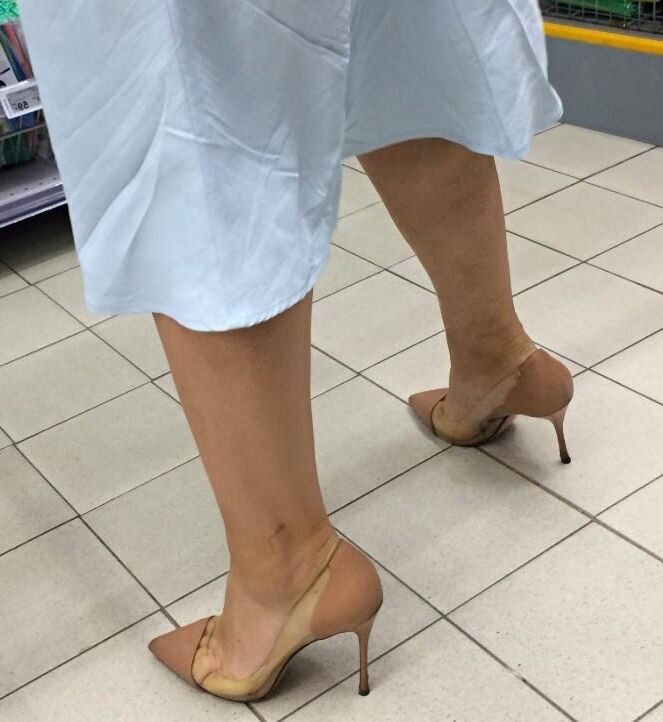 Mulher de salto transparente/nu no supermercado