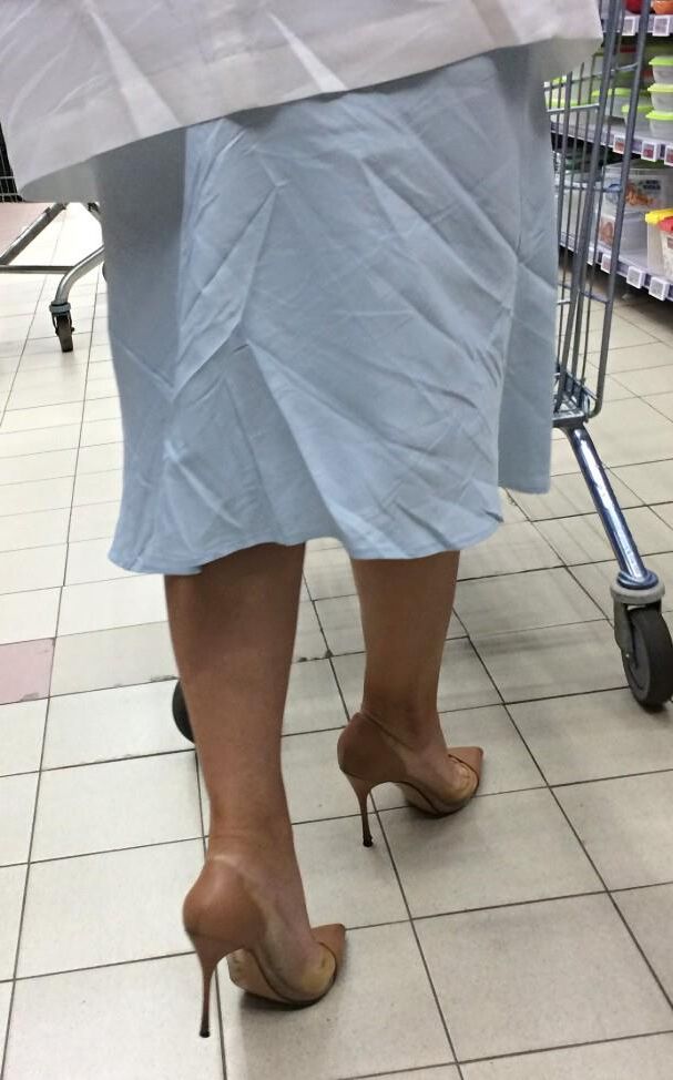 Mulher de salto transparente/nu no supermercado