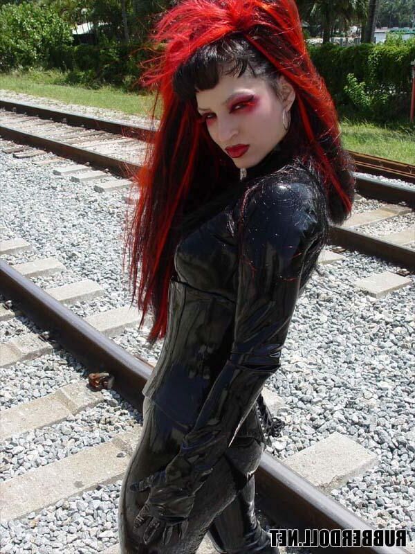 Kinky doll in black latex catsuit and public pussy spreading