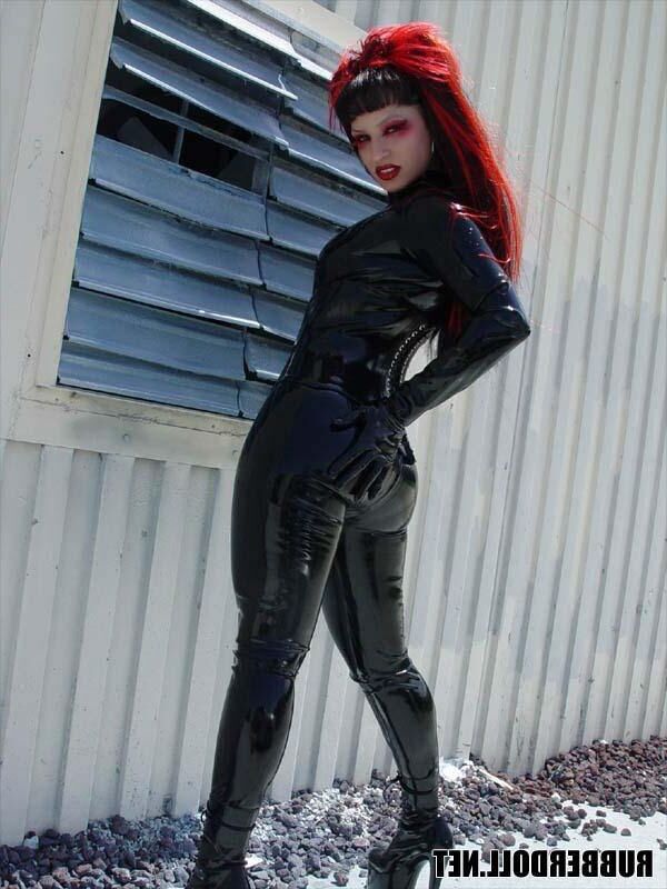 Kinky doll in black latex catsuit and public pussy spreading