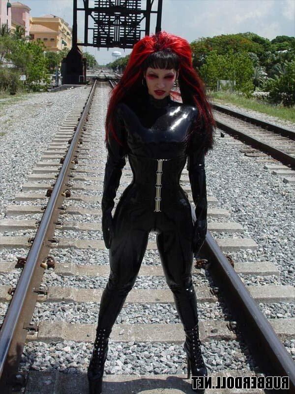 Kinky doll in black latex catsuit and public pussy spreading