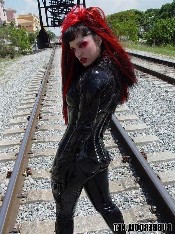 Kinky doll in black latex catsuit and public pussy spreading