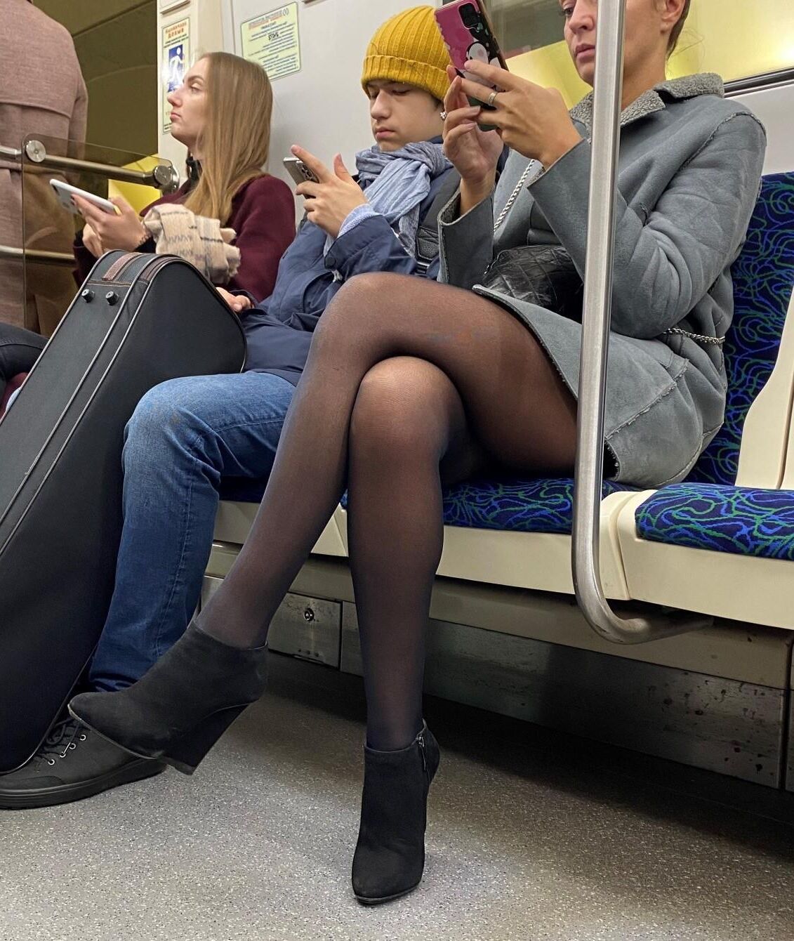 Mulher de meia-calça e botins de camurça no metrô