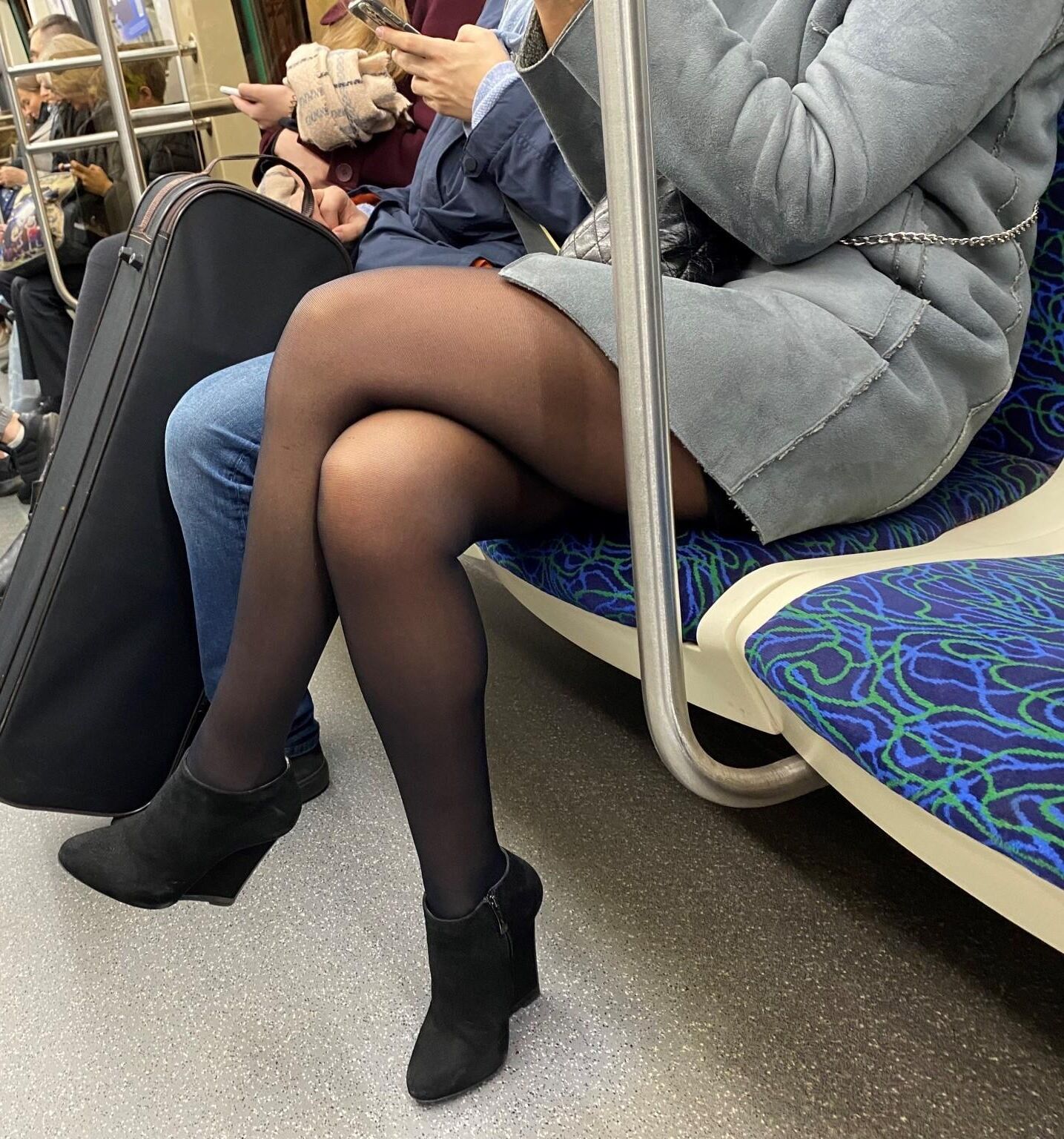 Mulher de meia-calça e botins de camurça no metrô