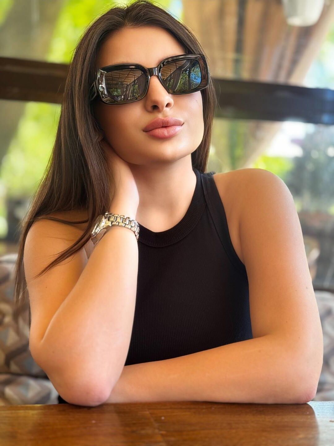 Black sleeveless tops and metal wristwatches #