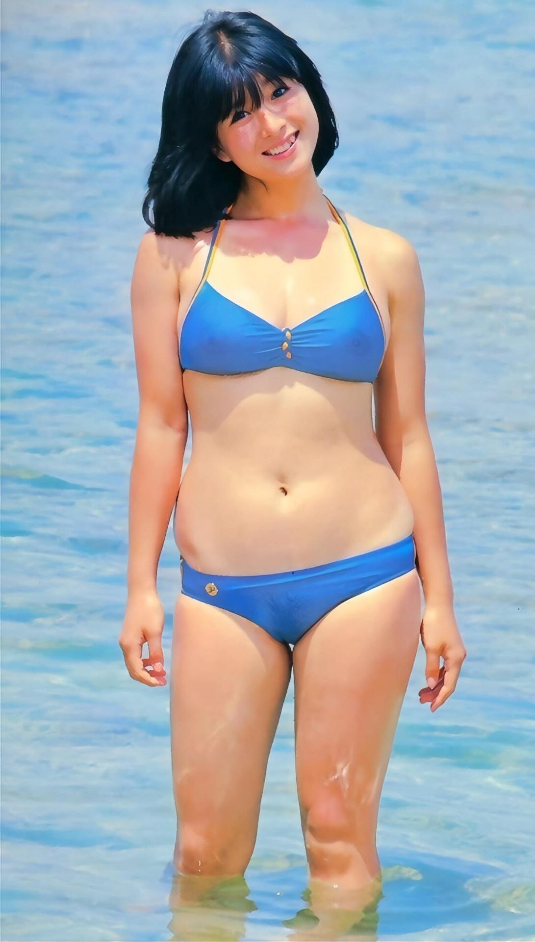 Japanische Frau, die das Meer genießt