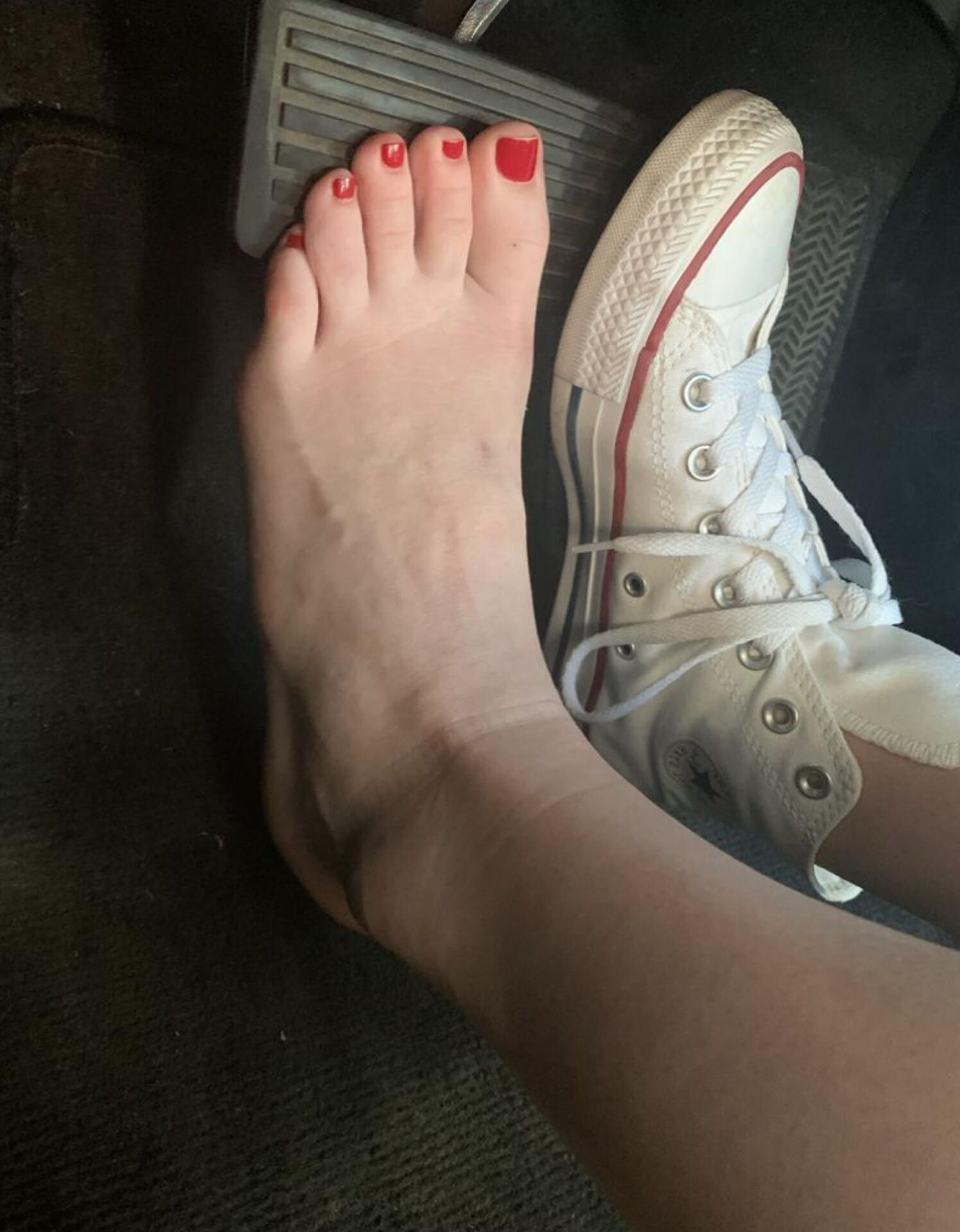 Heather removing her sweaty Converse in the car