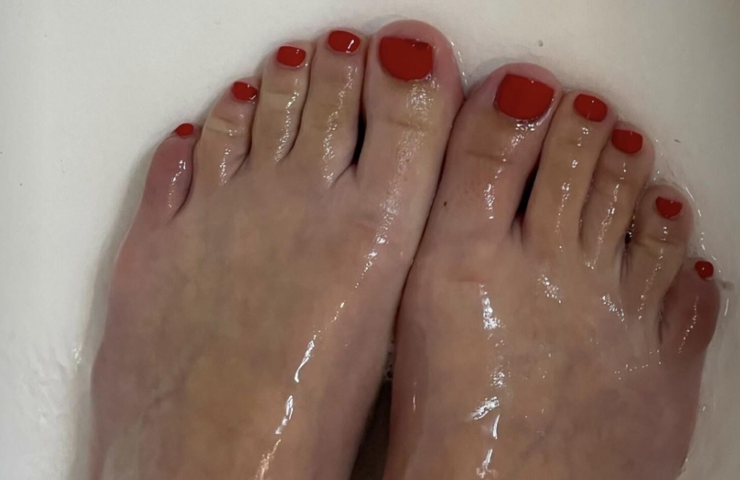 彼女の赤いつま先を見せている年のクリスティン