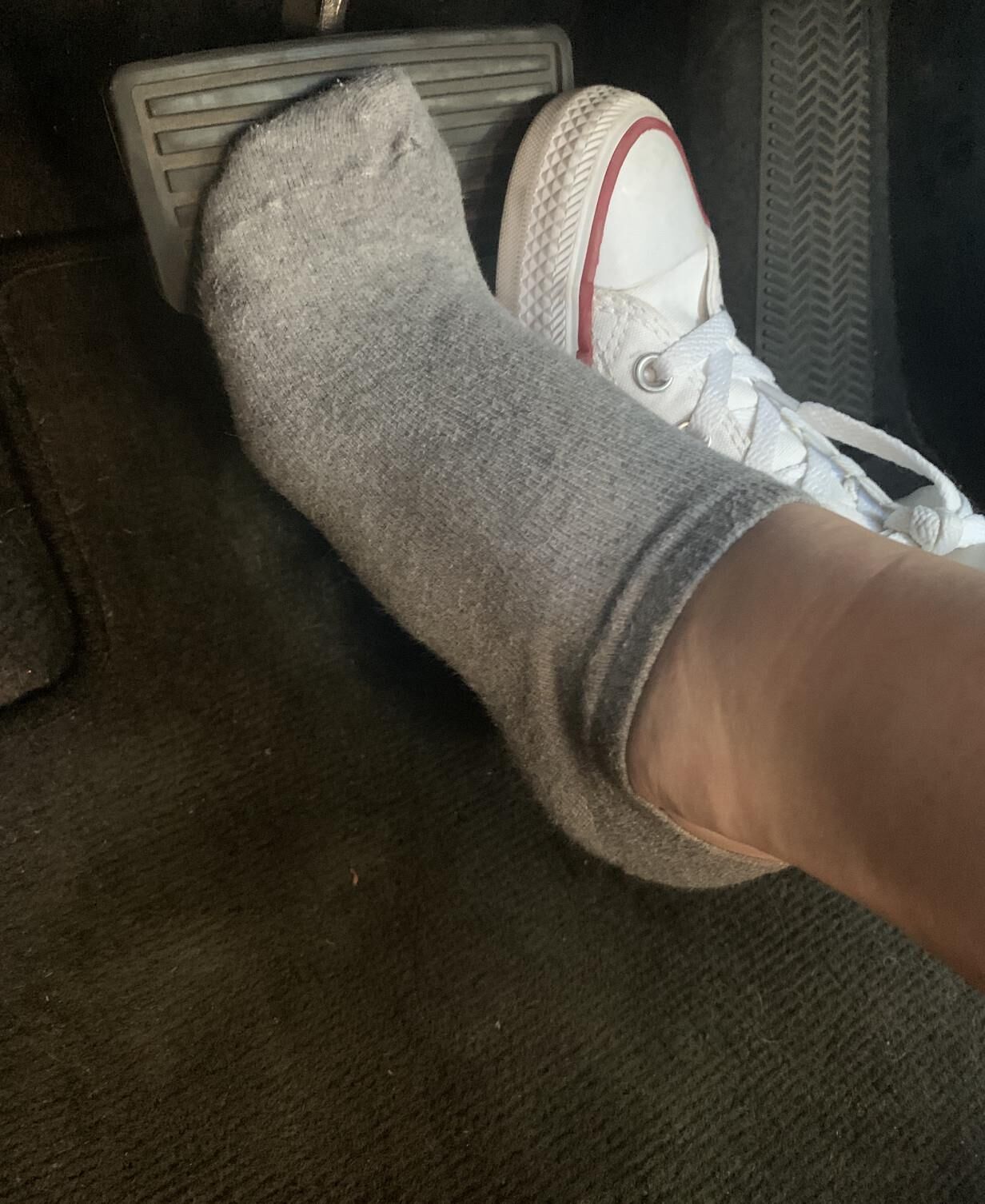 Heather removing her sweaty Converse in the car