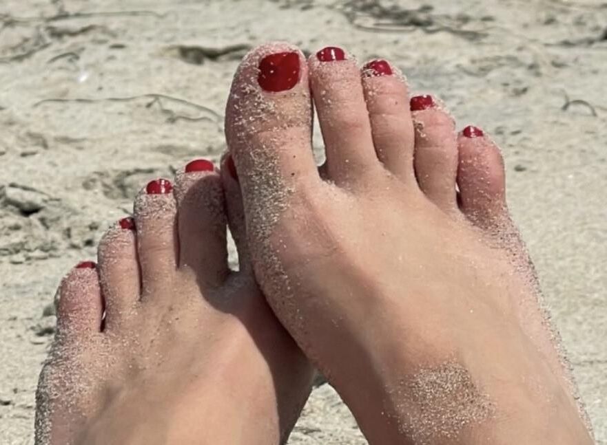 Kristin mostrando su bola drenando los dedos de los pies en la arena