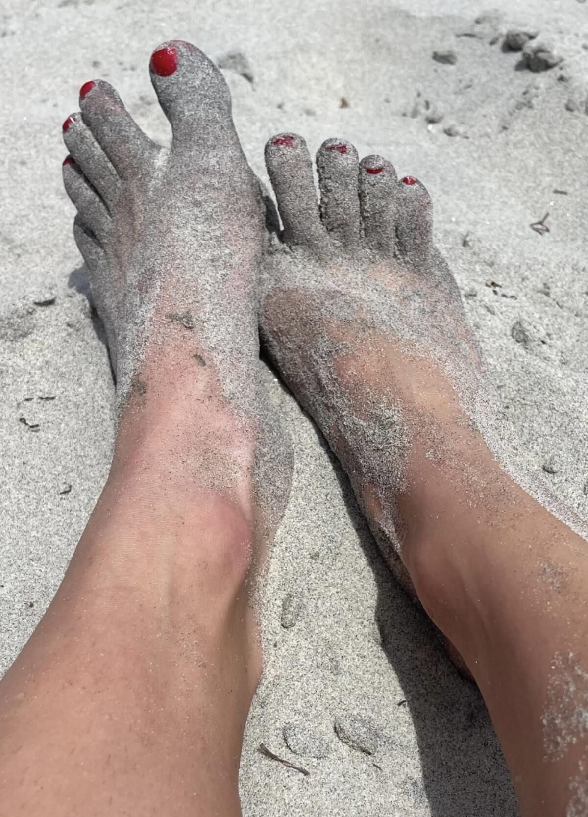 Kristin mostrando su bola drenando los dedos de los pies en la arena