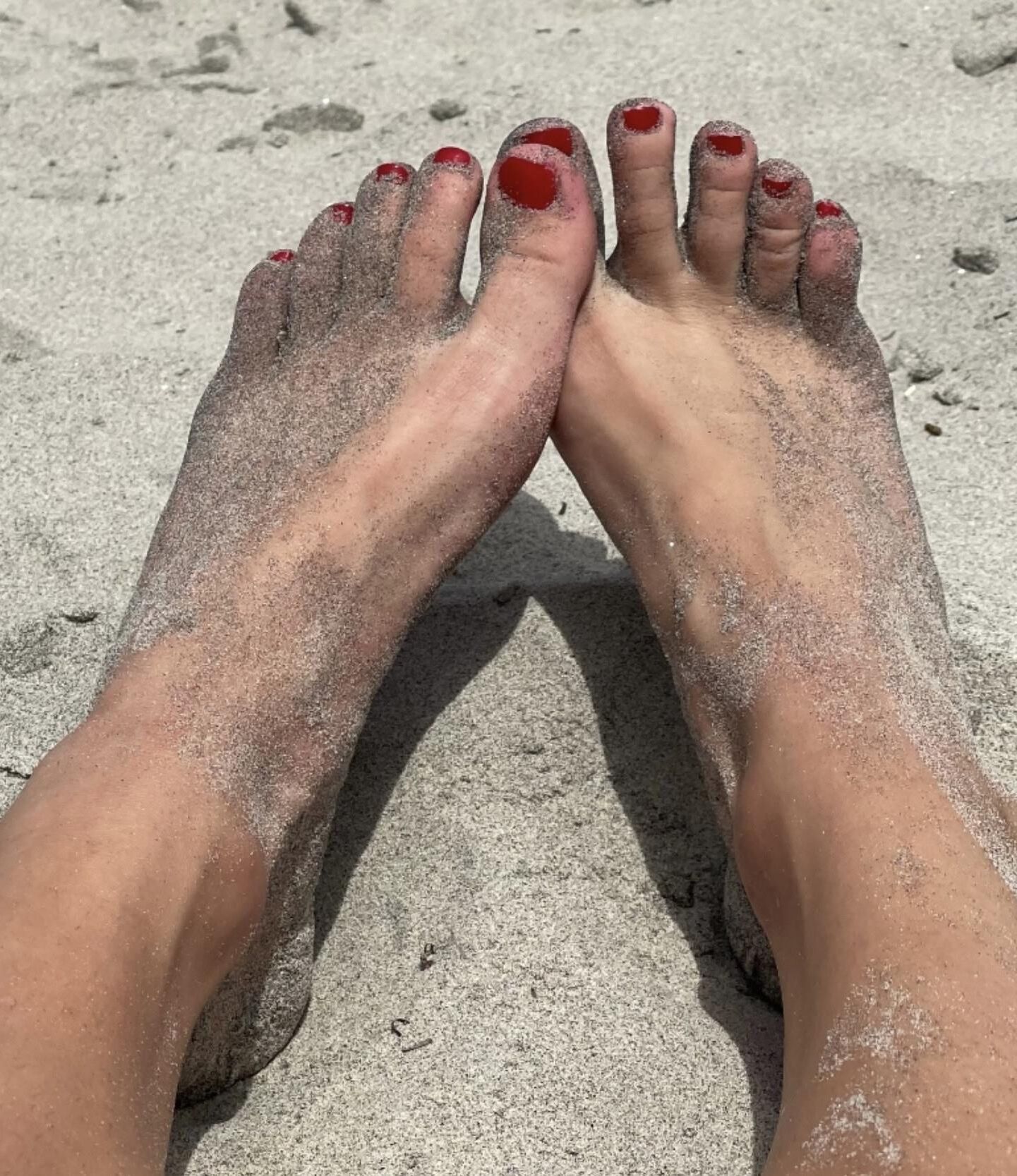 Kristin mostrando su bola drenando los dedos de los pies en la arena