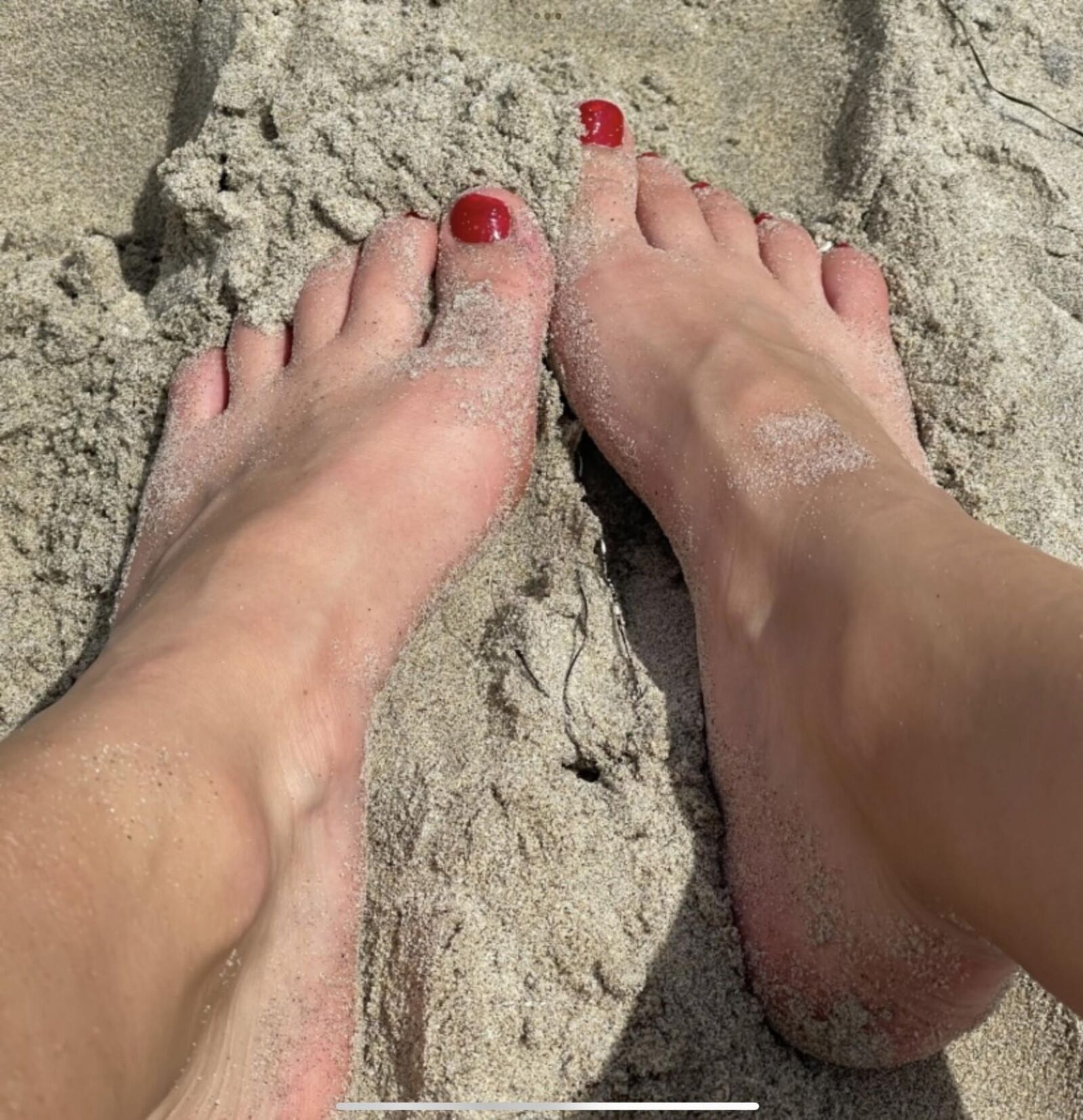Kristin mostrando su bola drenando los dedos de los pies en la arena