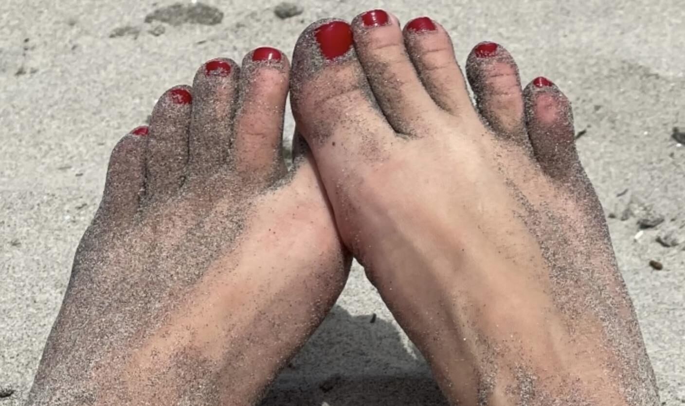 Kristin mostrando su bola drenando los dedos de los pies en la arena