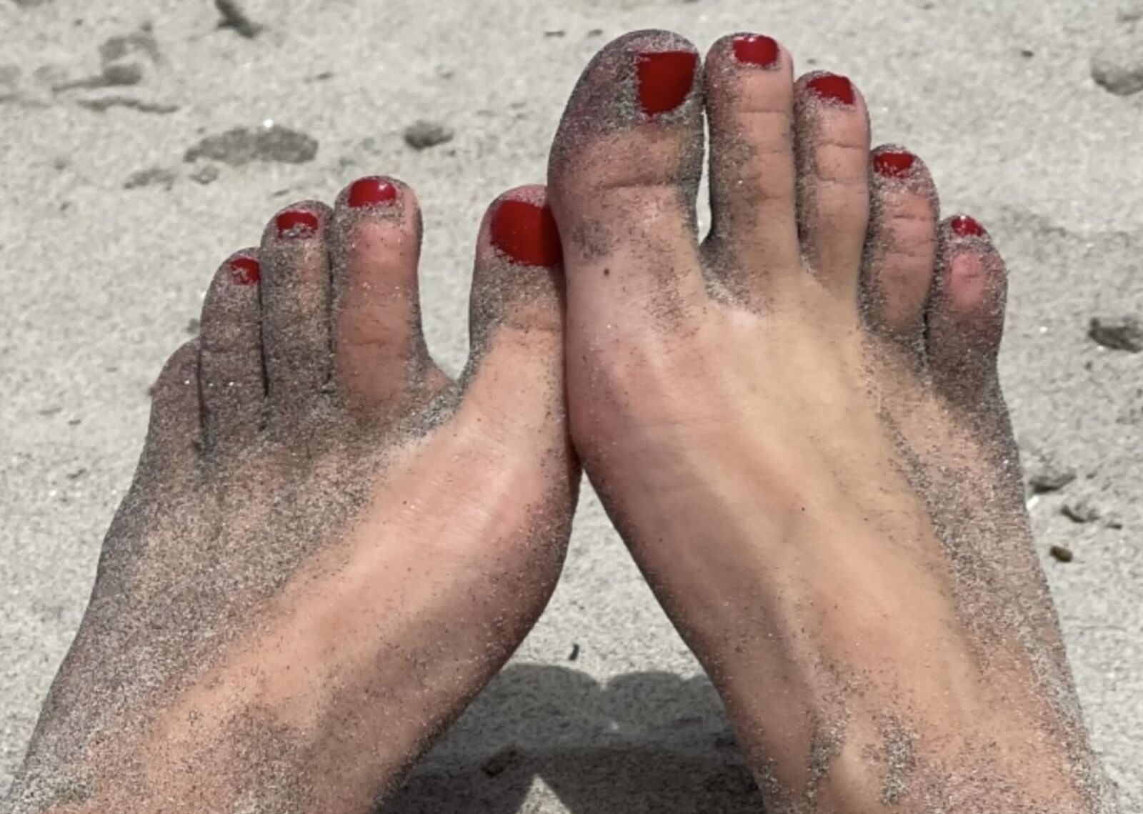 Kristin mostrando su bola drenando los dedos de los pies en la arena