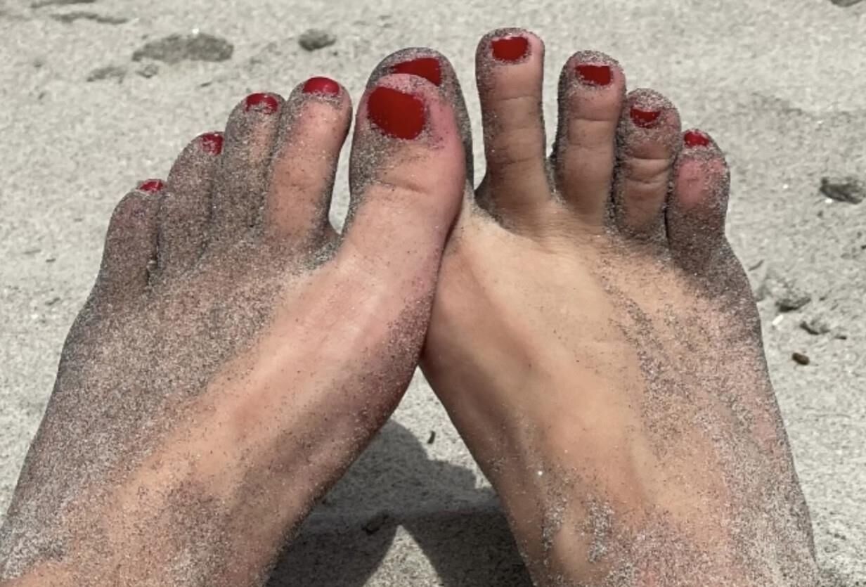 Kristin mostrando su bola drenando los dedos de los pies en la arena