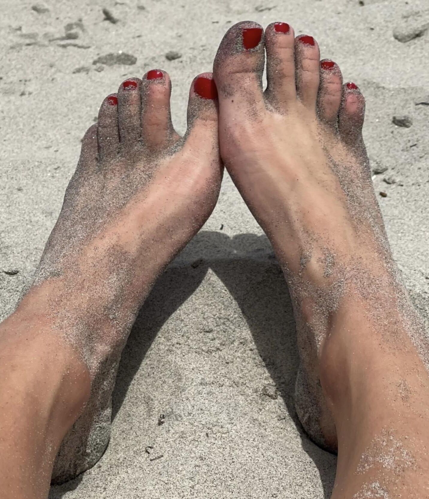 Kristin mostrando su bola drenando los dedos de los pies en la arena