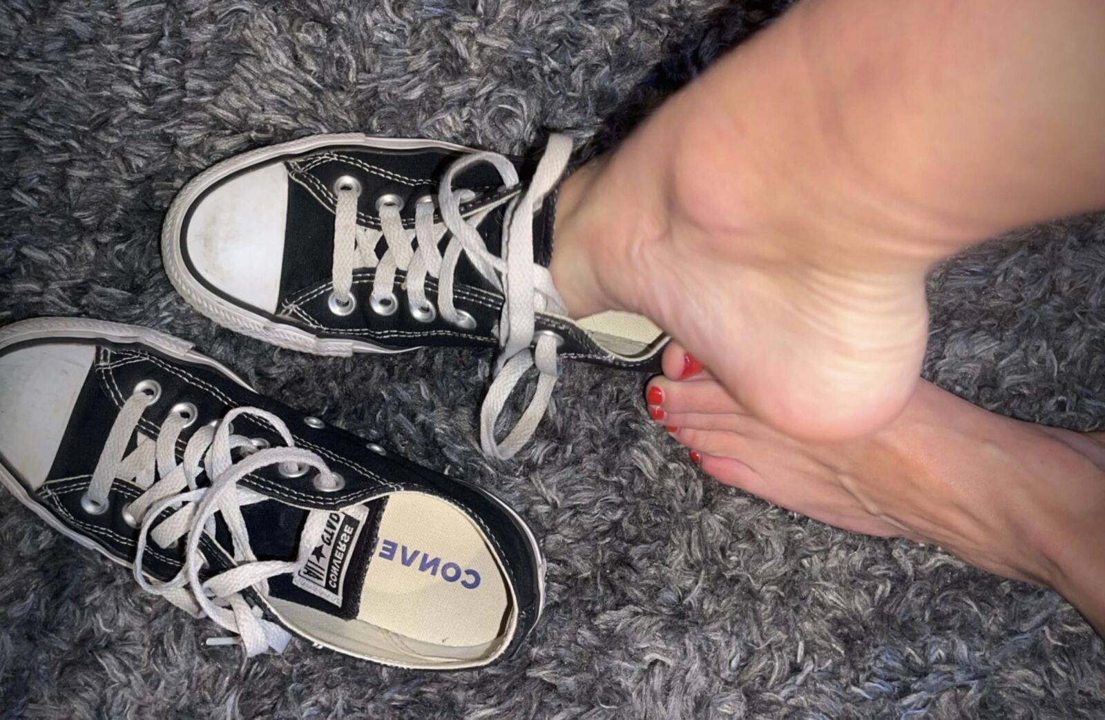 Los dedos rojos malolientes de Kristin salen de Converse sin calcetines