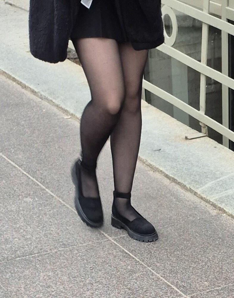 Girl in mini skirt, black pantyhose and suede sandals