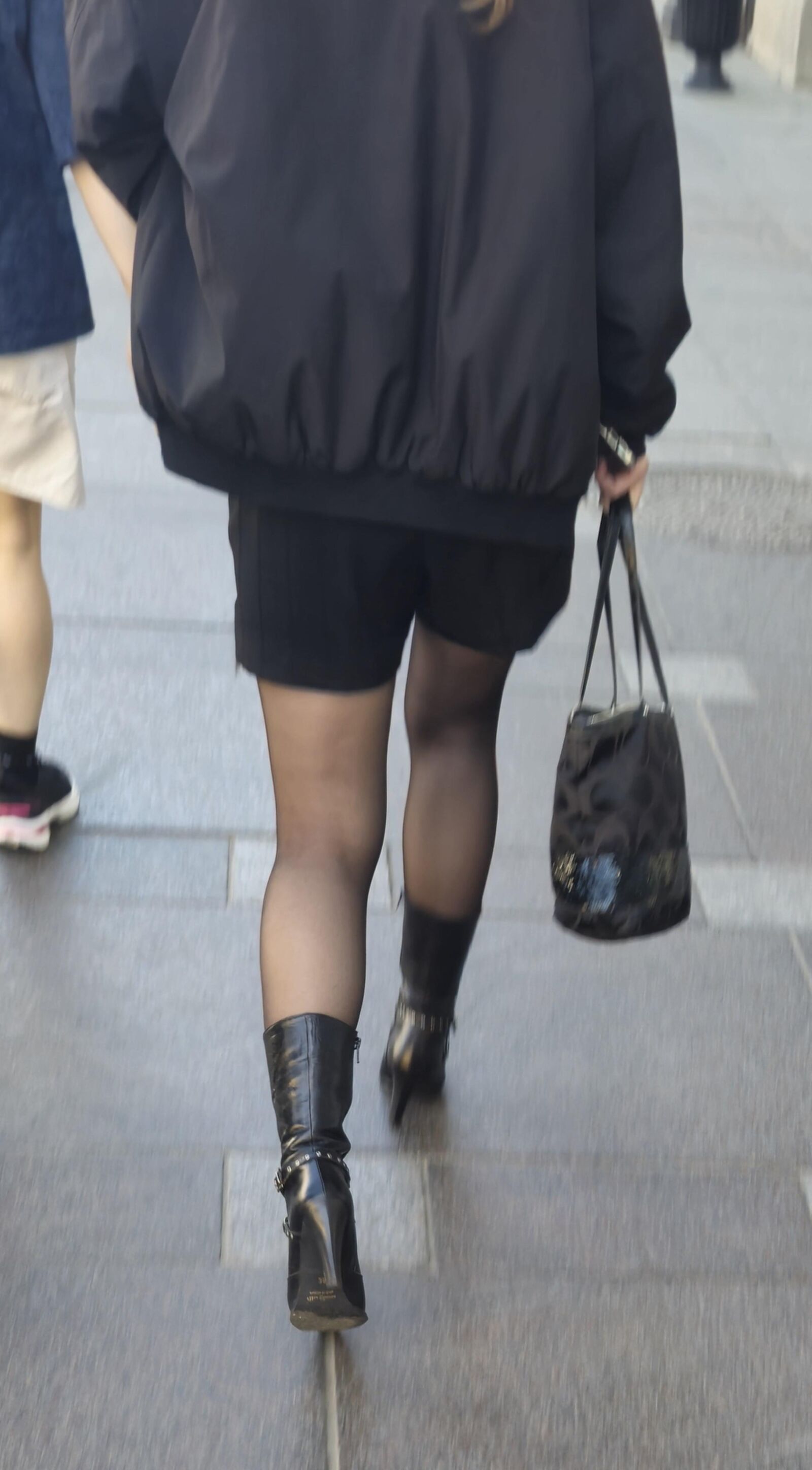 Girl in black pantyhose and leather boots
