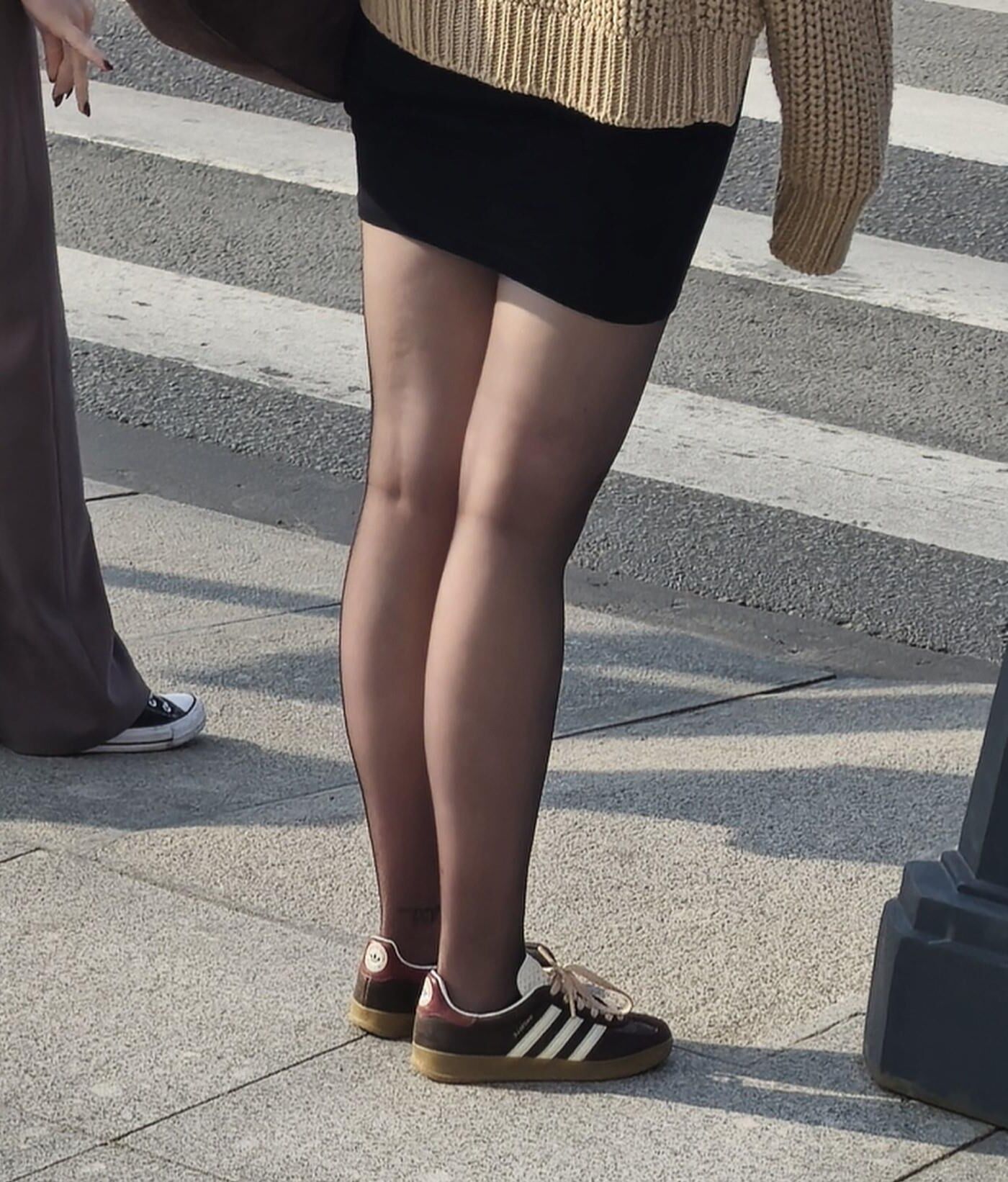 黒いタイツの女の子、ミニスカート、スニーカー