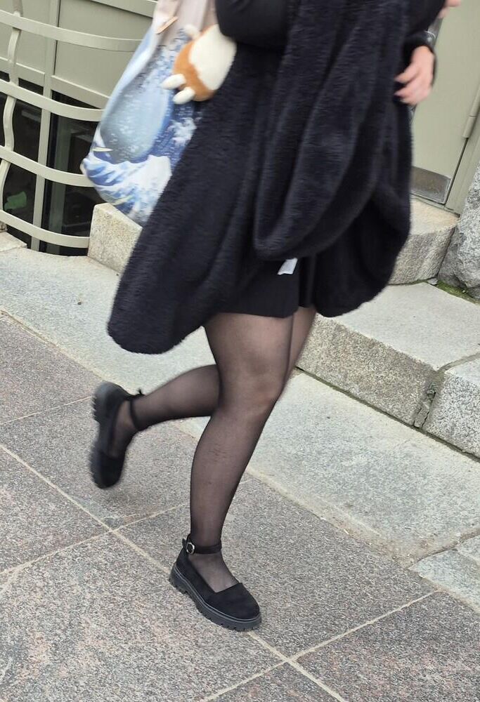 Girl in mini skirt, black pantyhose and suede sandals