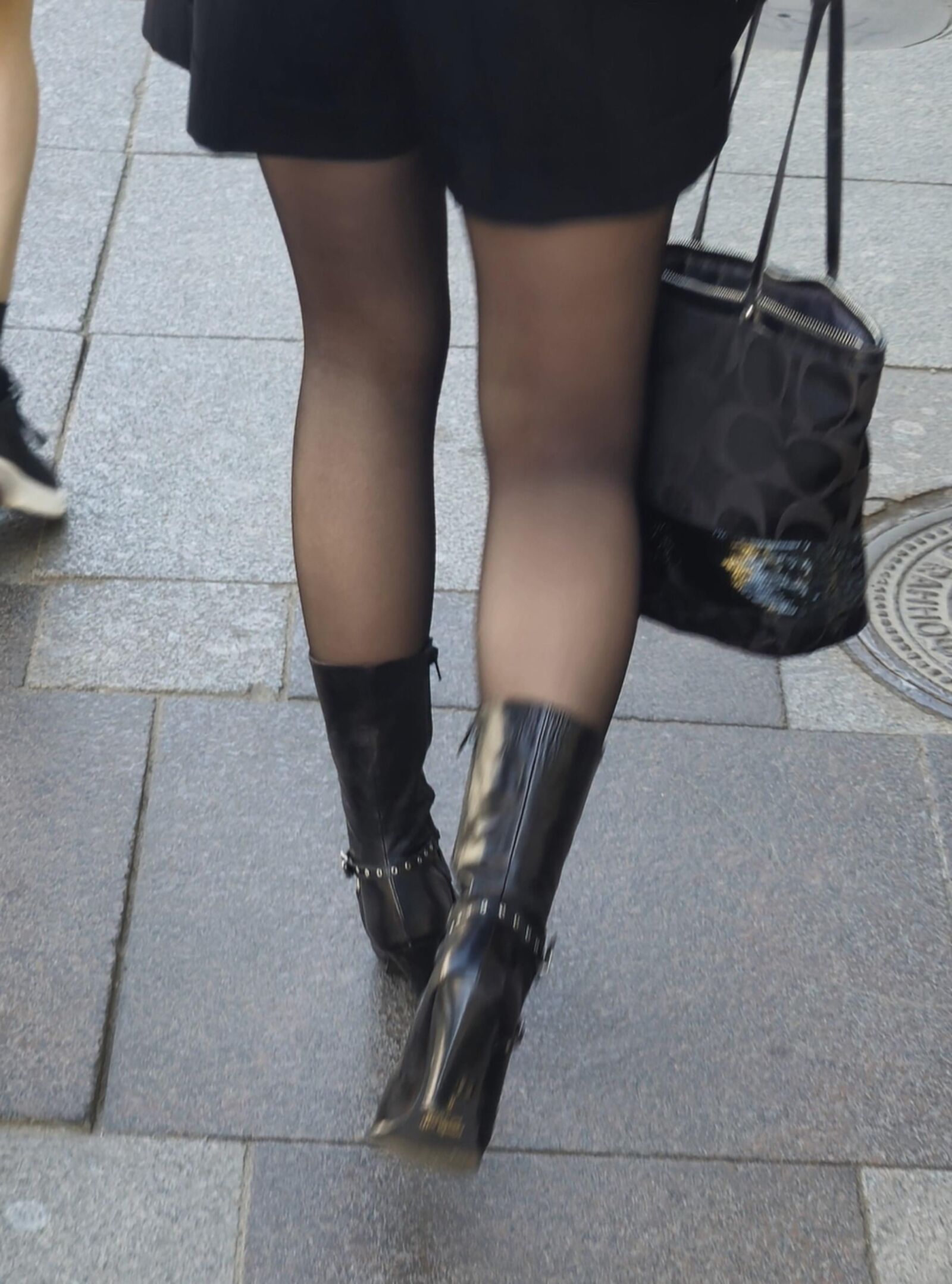 Girl in black pantyhose and leather boots