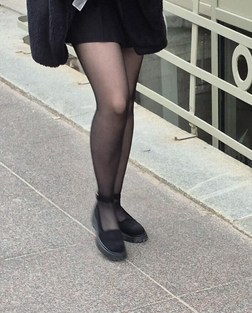 Girl in mini skirt, black pantyhose and suede sandals