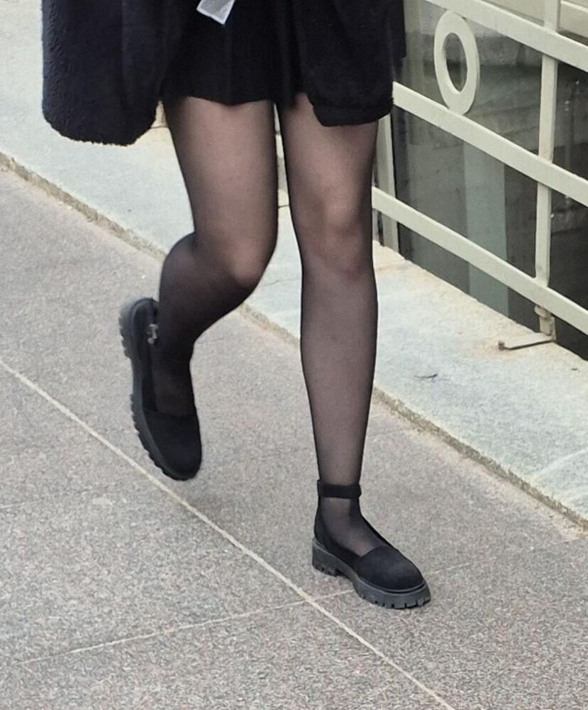 Girl in mini skirt, black pantyhose and suede sandals