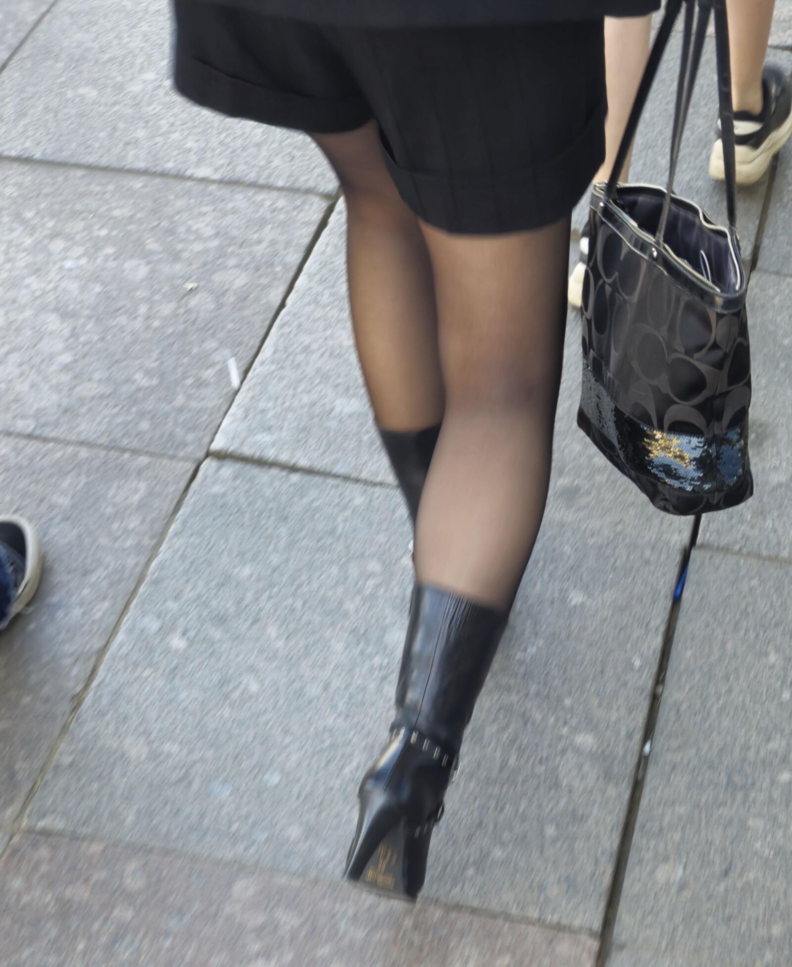 Girl in black pantyhose and leather boots