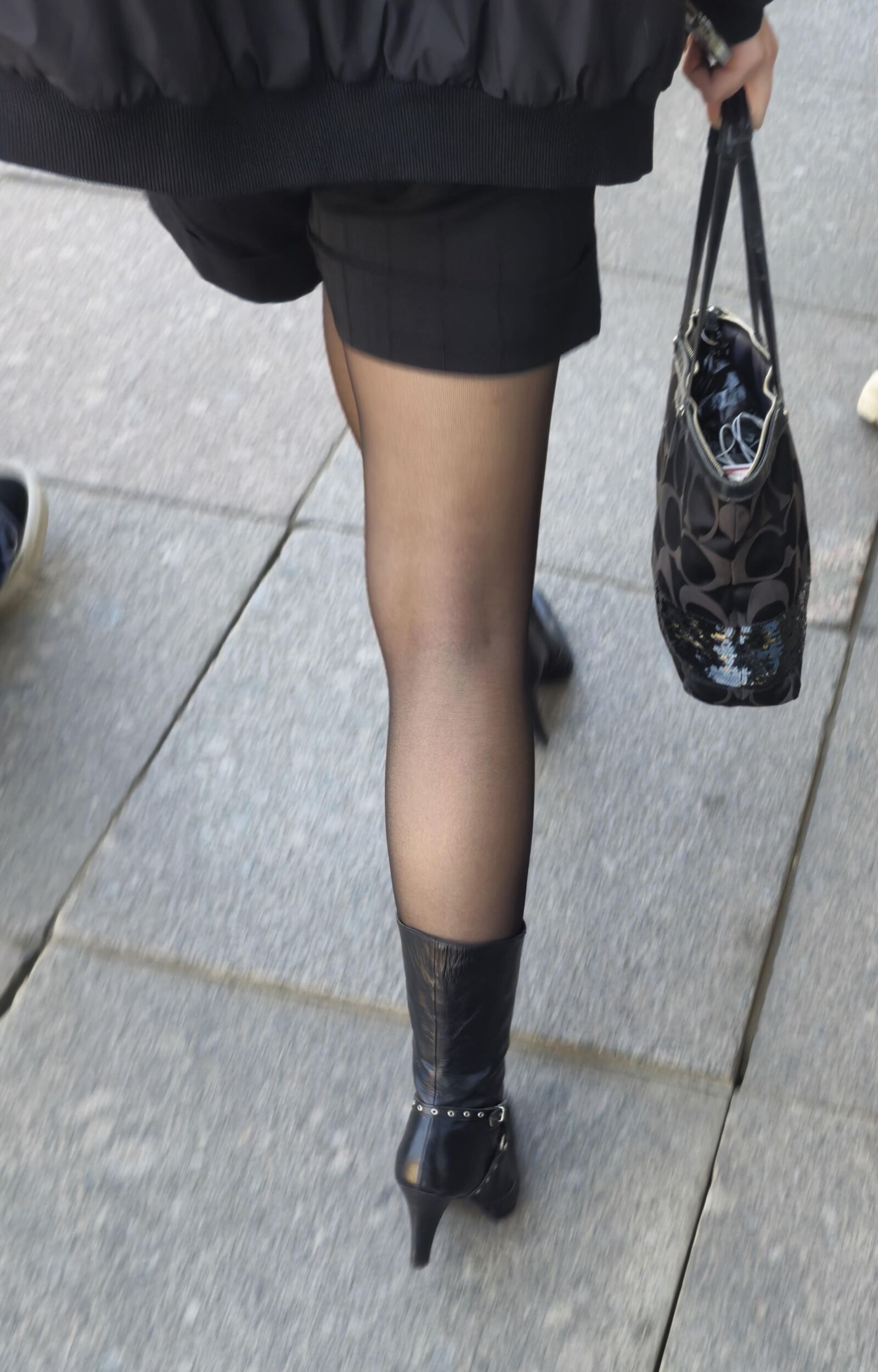 Girl in black pantyhose and leather boots