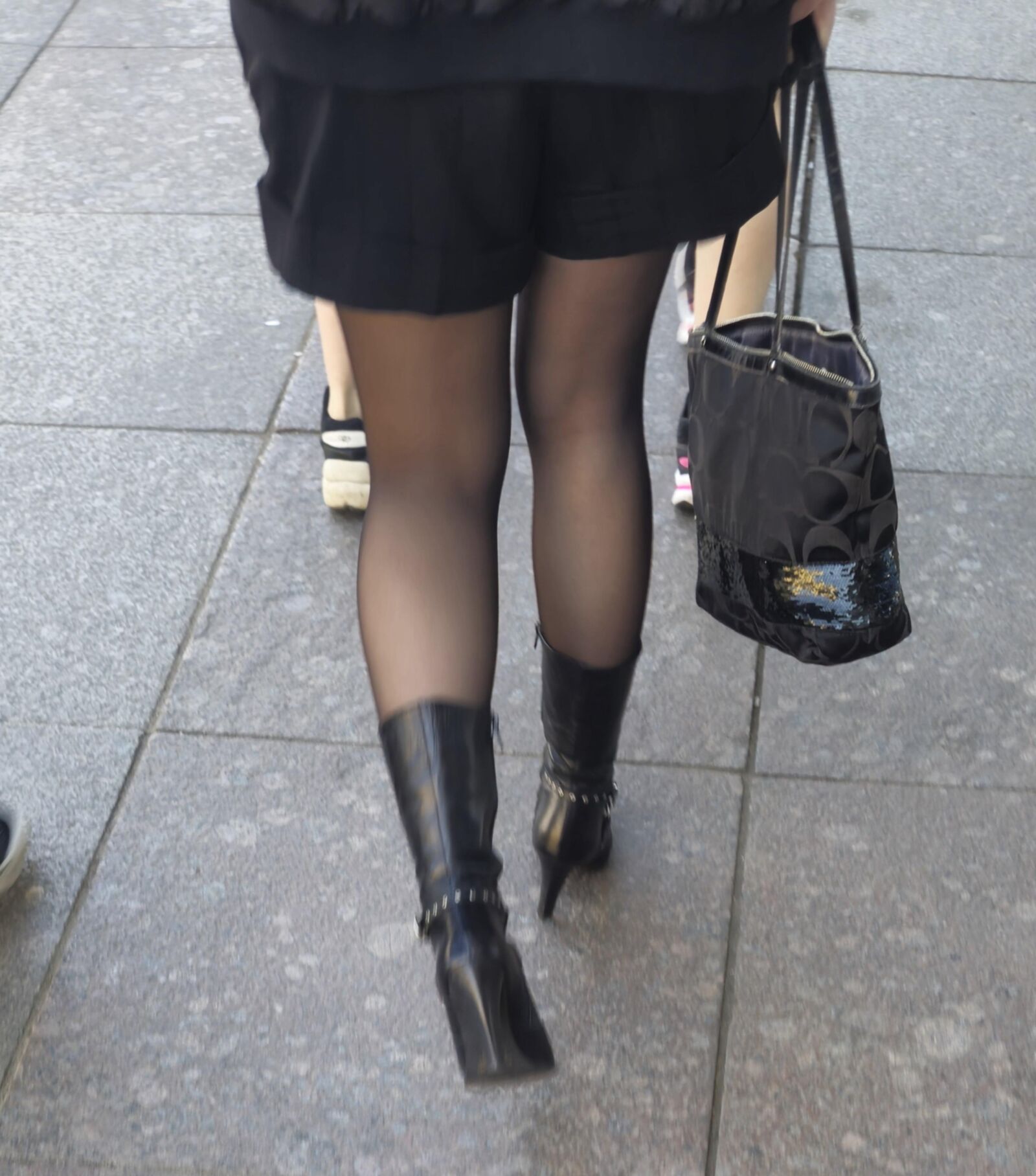 Girl in black pantyhose and leather boots