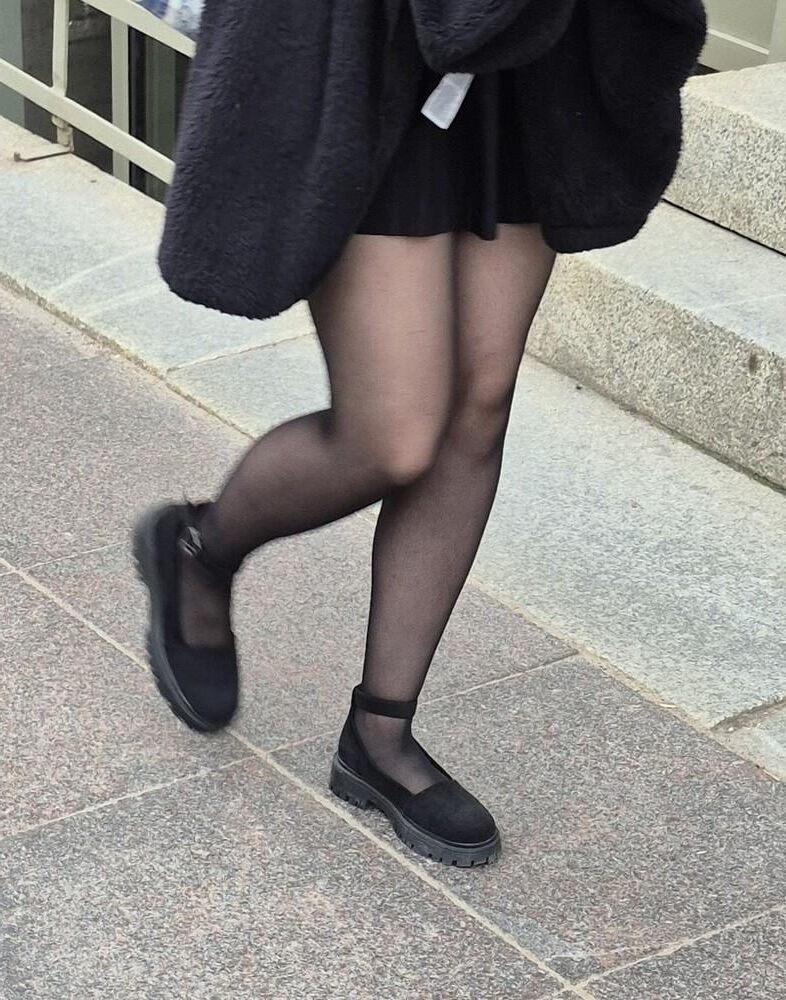 Girl in mini skirt, black pantyhose and suede sandals