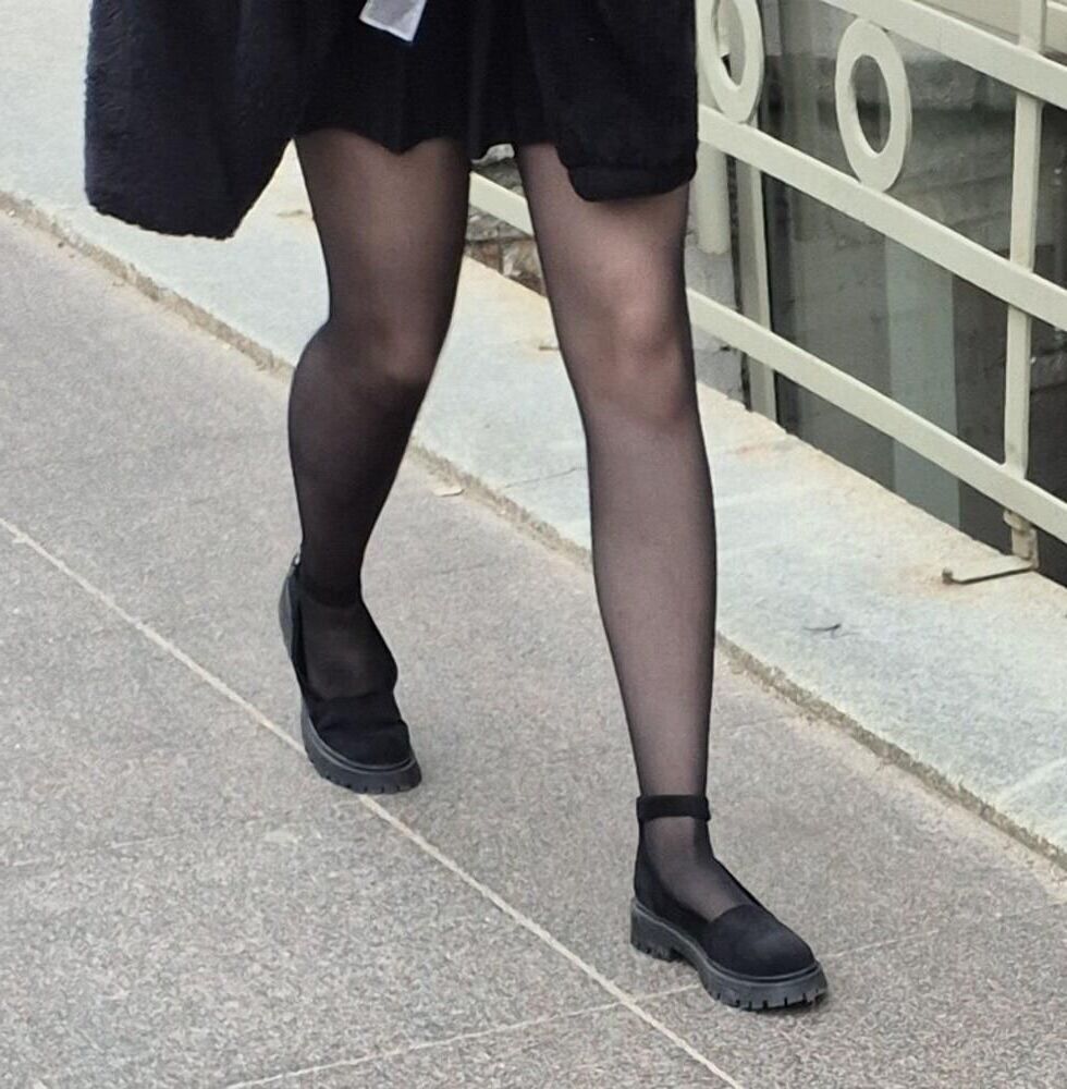 Girl in mini skirt, black pantyhose and suede sandals