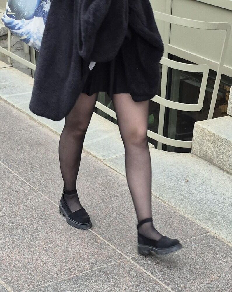 Girl in mini skirt, black pantyhose and suede sandals
