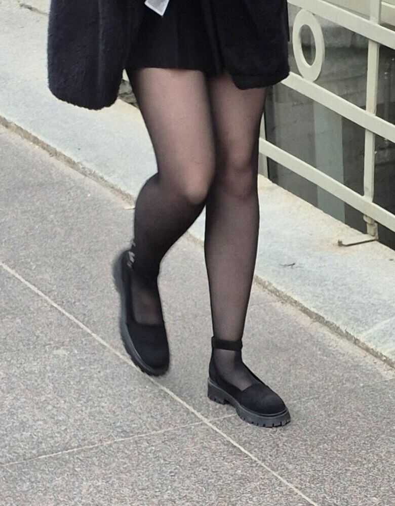 Girl in mini skirt, black pantyhose and suede sandals
