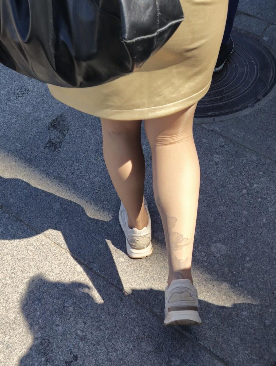 光沢のあるパンストとサテンのスカートの女の子