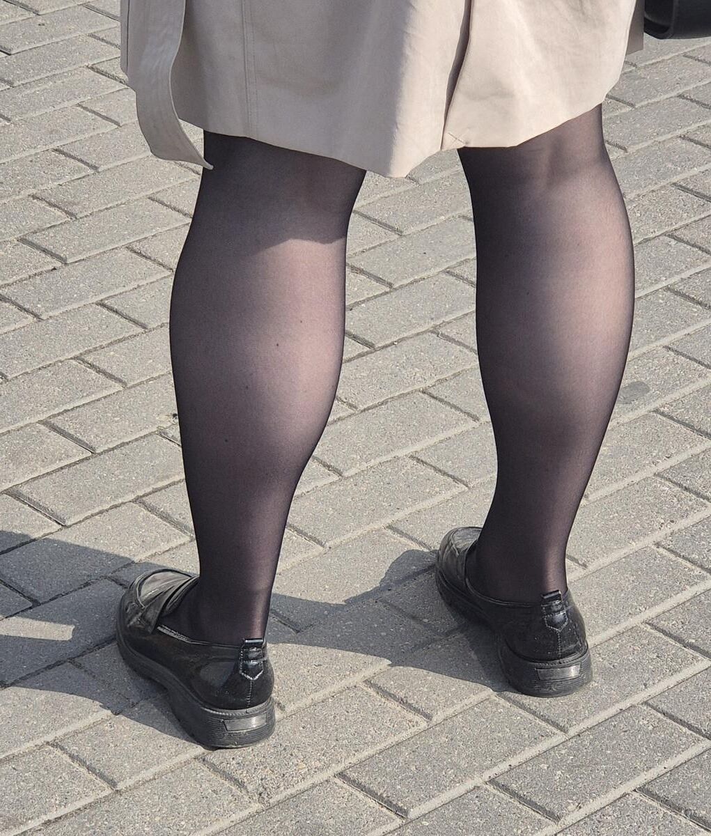 マントとブラックパンストの女性