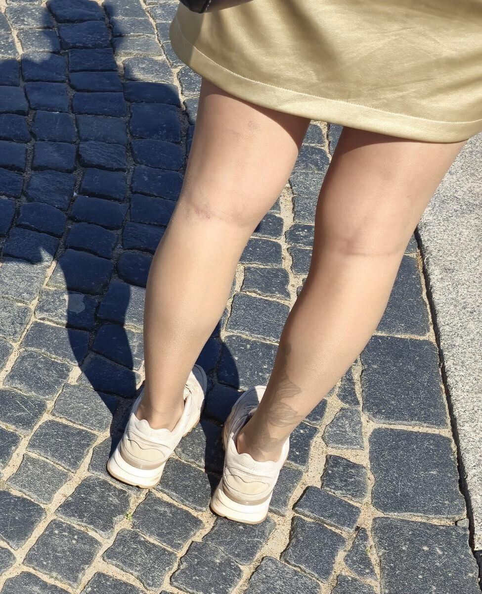 光沢のあるパンストとサテンのスカートの女の子