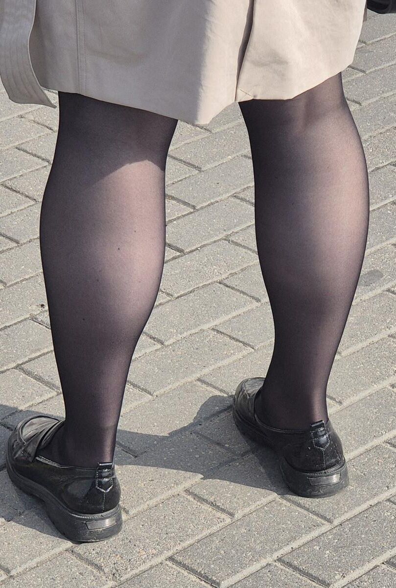 マントとブラックパンストの女性