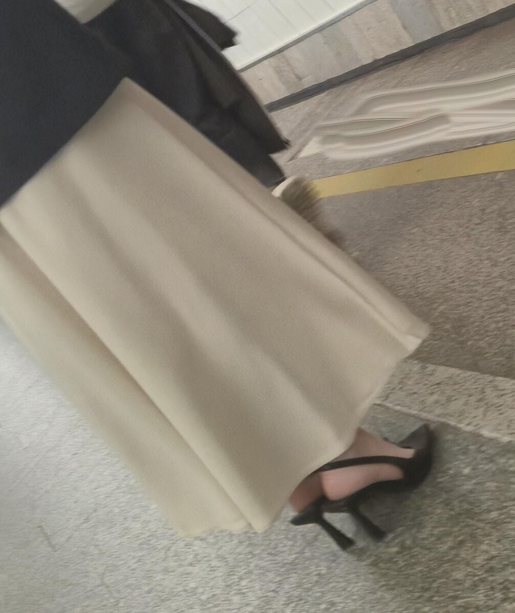 長いサテンのドレス、かかと、ジャケットを着た女の子