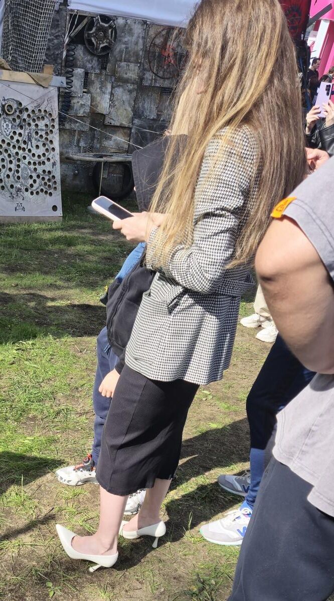 Garota de salto branco, vestido longo e jaqueta