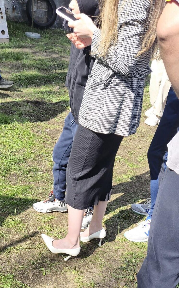 Garota de salto branco, vestido longo e jaqueta